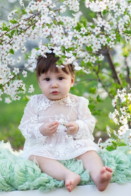 Portrait d'un bébé dans un jardin avec des pommiers en fleurs