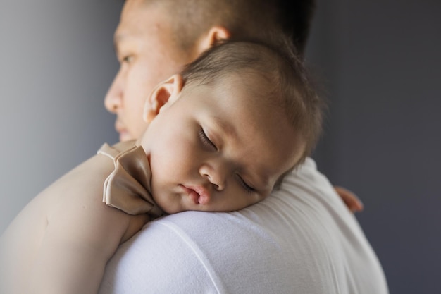 Portrait de bébé dormir sur l'épaule du père