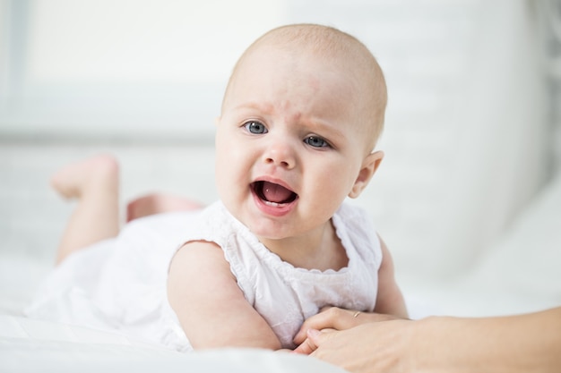 Portrait d'un bébé sur le lit dans sa chambre