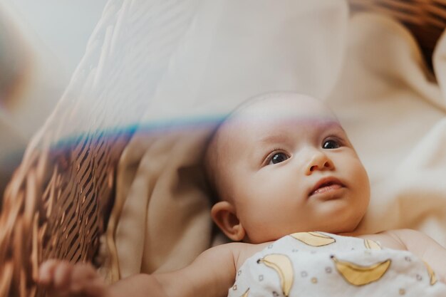 Portrait d'un bébé mignon couché dans son lit mais ne dormant pas