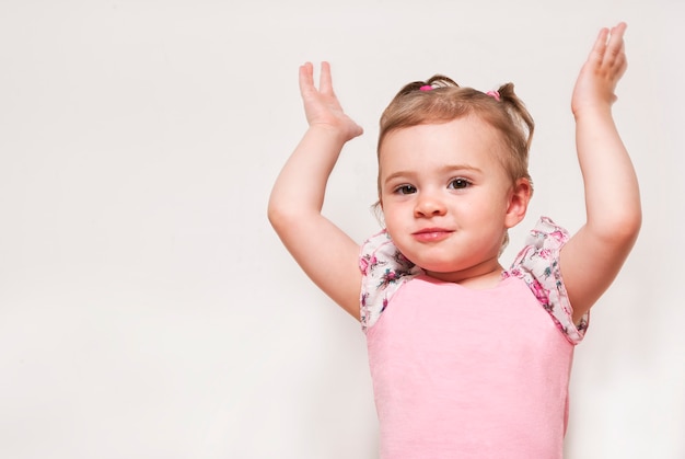 Portrait d'un bébé mignon avec levant les mains vers le haut