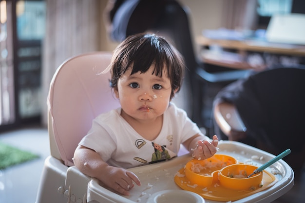 Portrait de bébé mignon manger sale sur la table