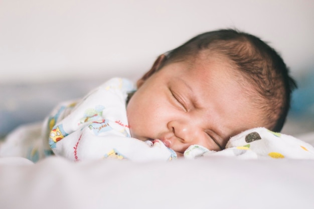 Portrait d'un bébé mignon qui dort sur le lit