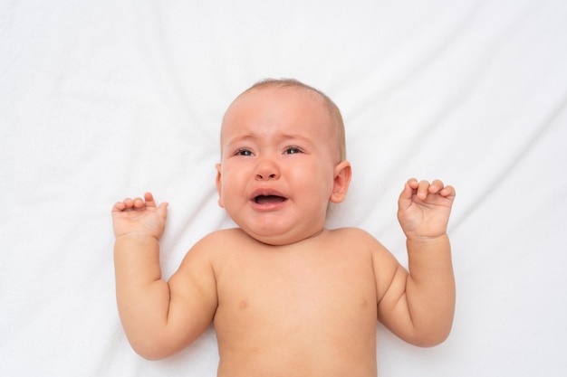 Portrait d'un bébé qui pleure au lit, vue de dessus