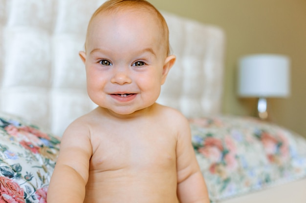 Portrait d'un bébé rampant sur le lit dans sa chambre