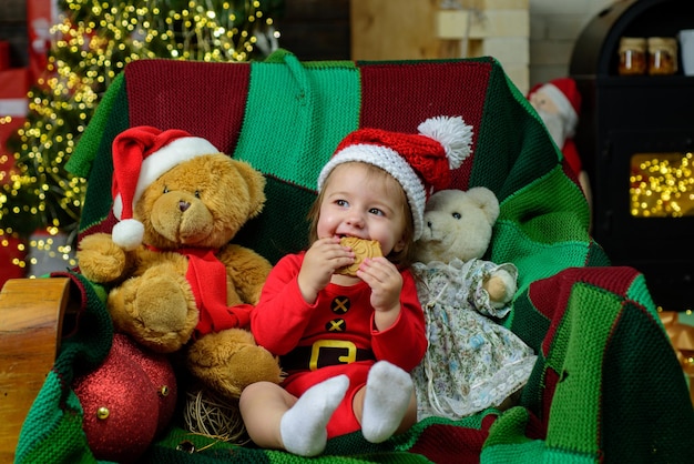 Portrait d'un bébé souriant heureux en chapeau de Noël à la maison. Kid profiter des vacances.