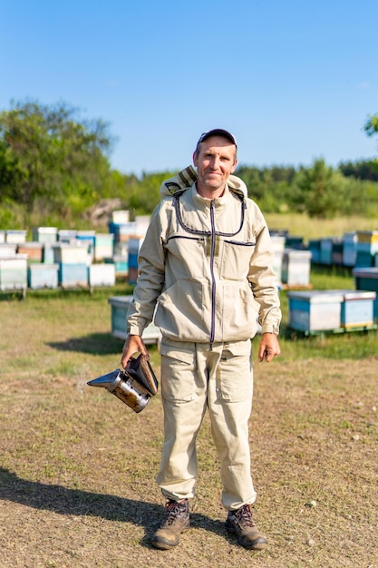 Portrait de bel apiculteur Apiculteur en costume d'apiculture protecteur