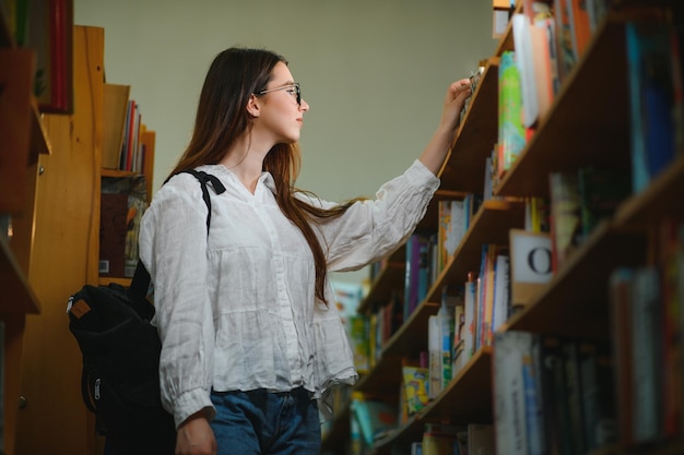 Portrait d&#39;un bel étudiant dans une bibliothèque