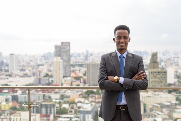 Portrait d'un bel homme d'affaires africain portant un costume et une cravate sur le toit de la ville