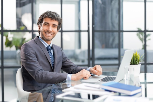 Portrait de bel homme d'affaires assis au bureau