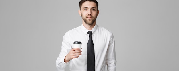 Portrait d'un bel homme d'affaires en costume formel avec une tasse de café