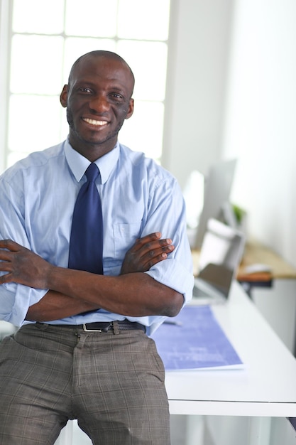 Portrait d'un bel homme d'affaires noir debout au bureau