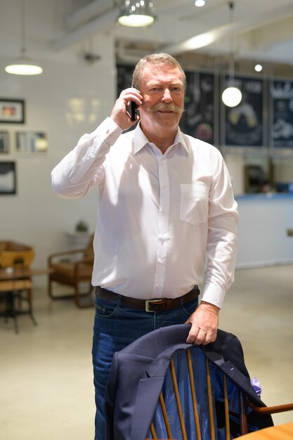 Portrait de bel homme d'affaires senior avec moustache au café