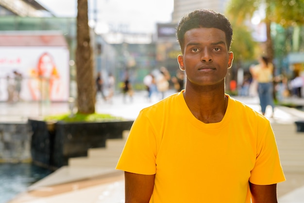 Portrait d'un bel homme africain noir portant un t-shirt jaune à l'extérieur de la ville de Bangkok, Thaïlande