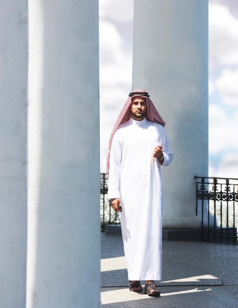 Portrait d'un bel homme arabe marchant parmi les colonnes