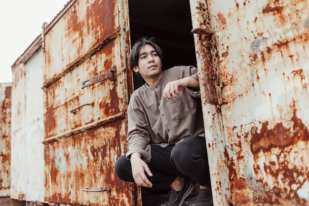 Portrait de bel homme asiatique debout dans le vieux train vintage