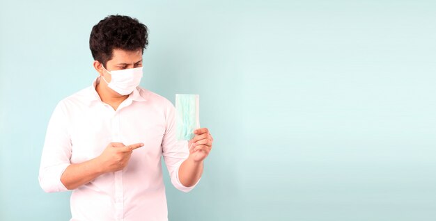 Portrait d'un bel homme asiatique Suggérer comment utiliser un masque et porter un masque médical, Recommander la prévention des virus et de diverses maladies. isolé en studio avec espace copie.