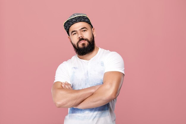 Portrait de bel homme barbu en casquette regardant la caméra