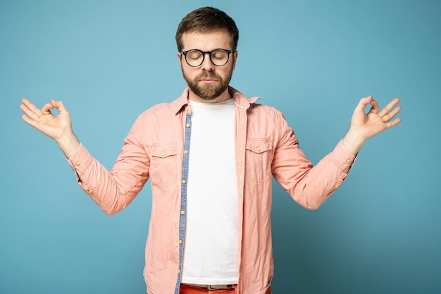 Portrait d'un bel homme barbu détendu calme avec des lunettes avec les yeux fermés