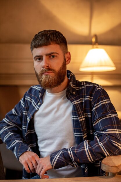 Portrait bel homme barbu portant une chemise à carreaux au café moderne.