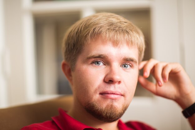 Portrait d'un bel homme blond à la recherche d'appareil photo