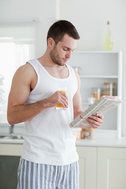 Portrait d&#39;un bel homme, boire du jus d&#39;orange en lisant les nouvelles