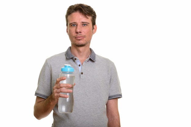 Portrait de bel homme caucasien tenant une bouteille d'eau