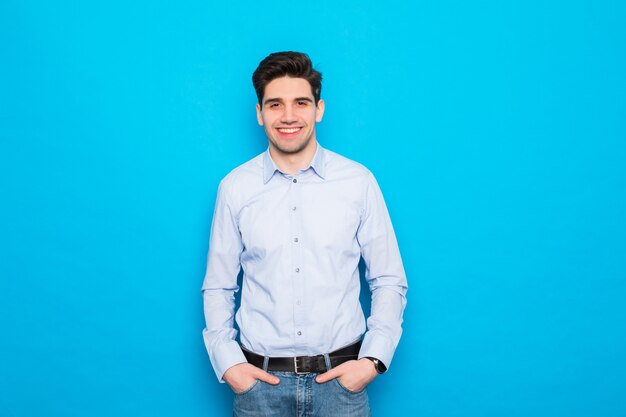 Portrait de bel homme debout isolé sur un espace bleu