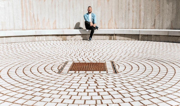 Portrait d'un bel homme hipster dans une veste en jean dans une grande ville dans la rue un concept de style de vie