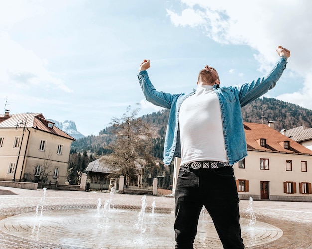 Portrait d'un bel homme hipster dans une veste en jean dans une grande ville dans la rue un concept de style de vie