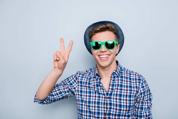 Portrait de bel homme avec des lunettes de soleil et signe de paix