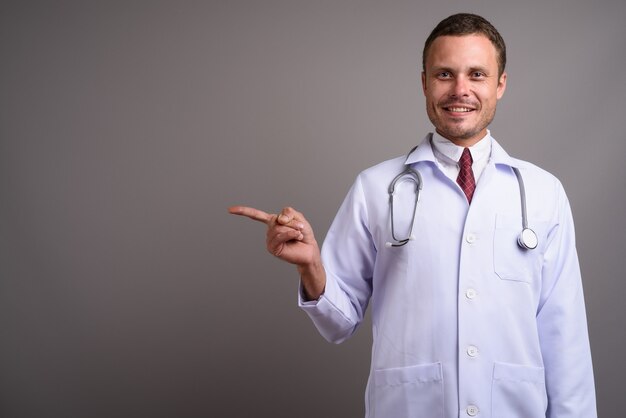 Portrait de bel homme médecin sur fond gris