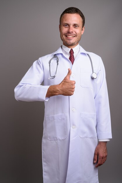 Portrait de bel homme médecin sur fond gris