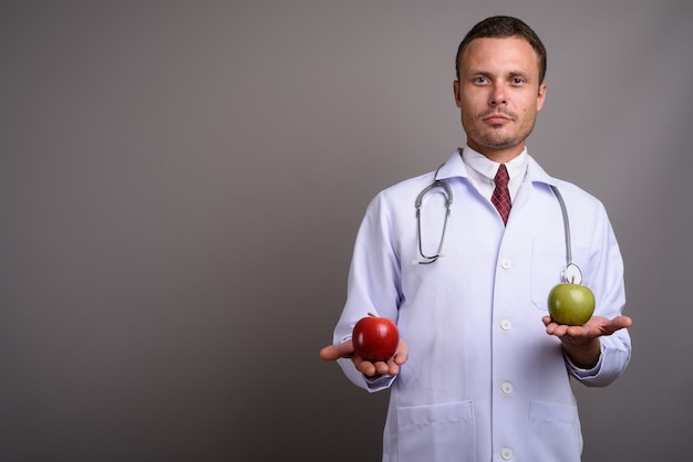 Portrait de bel homme médecin sur fond gris