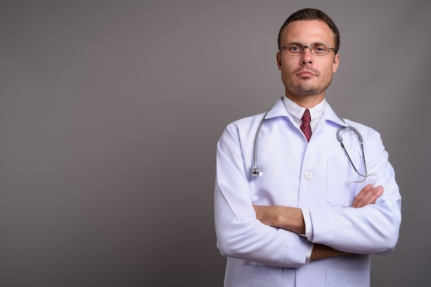 Portrait de bel homme médecin sur fond gris