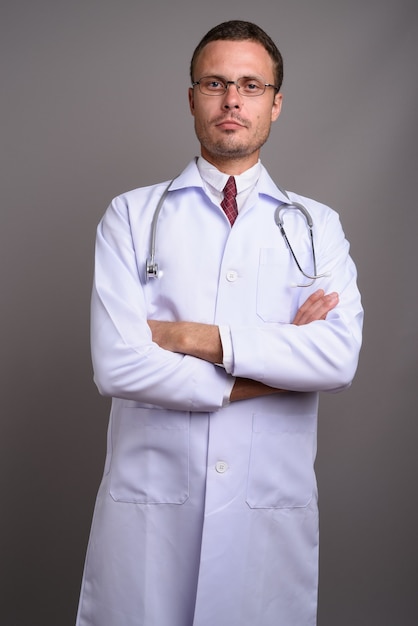 Portrait de bel homme médecin sur fond gris