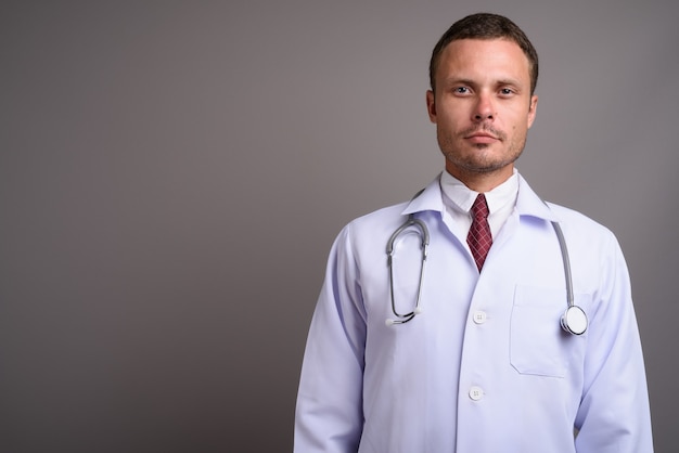 Portrait de bel homme médecin sur fond gris