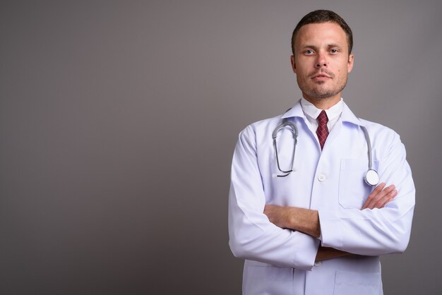 Portrait de bel homme médecin sur fond gris