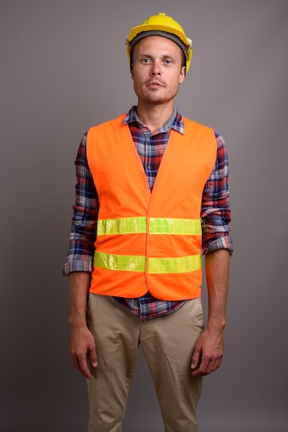 Portrait de bel homme ouvrier sur fond gris