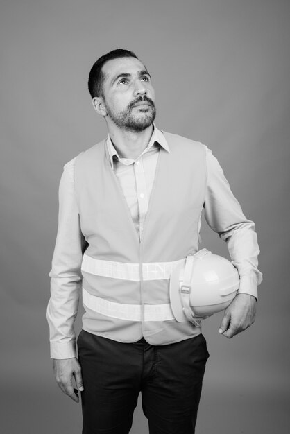 Portrait de bel homme persan barbu ouvrier du bâtiment sur gris en noir et blanc