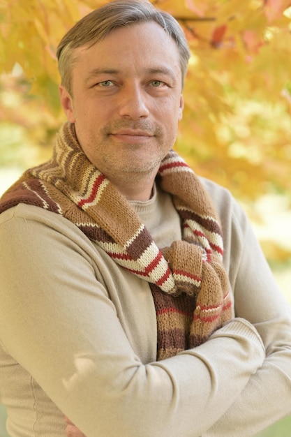 Portrait d'un bel homme posant dans un parc