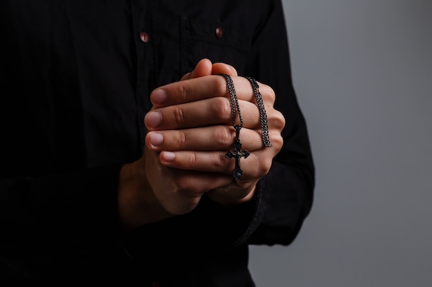 Portrait d'un bel homme priant sur fond gris