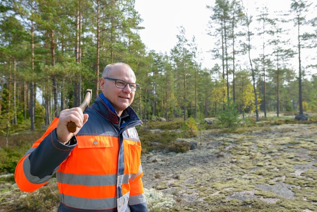 Portrait de bel homme scandinave mature prêt pour la récolte dans la forêt à l'extérieur