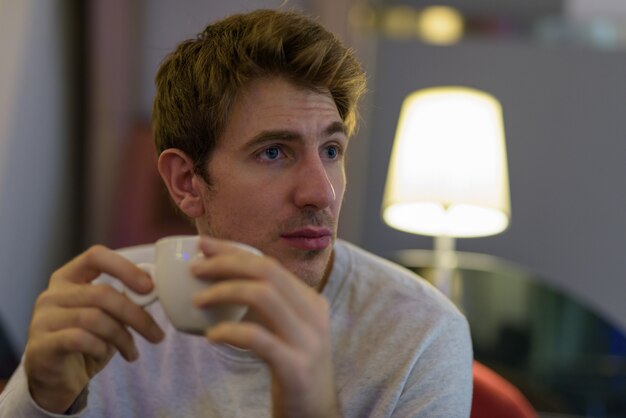 Portrait de bel homme se détendre au café à l'intérieur du centre commercial de la ville de Bangkok, Thaïlande