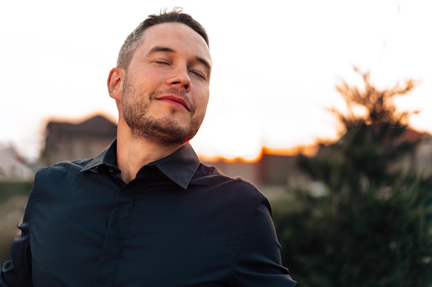 Photo portrait d'un bel homme à succès debout à l'extérieur