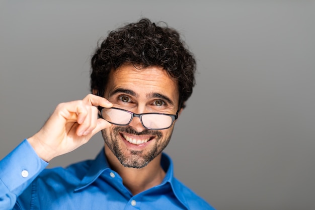 Portrait d'un bel homme tenant des lunettes