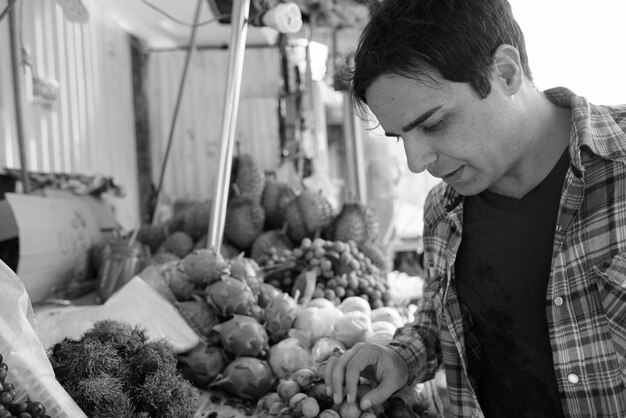 Portrait de bel homme touriste persan passer des vacances et explorer la ville de Bangkok en noir et blanc