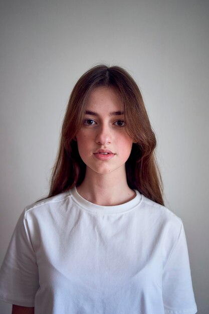 portrait d'une belle adolescente sur une chaise dans une pièce lumineuse dans un style minimaliste