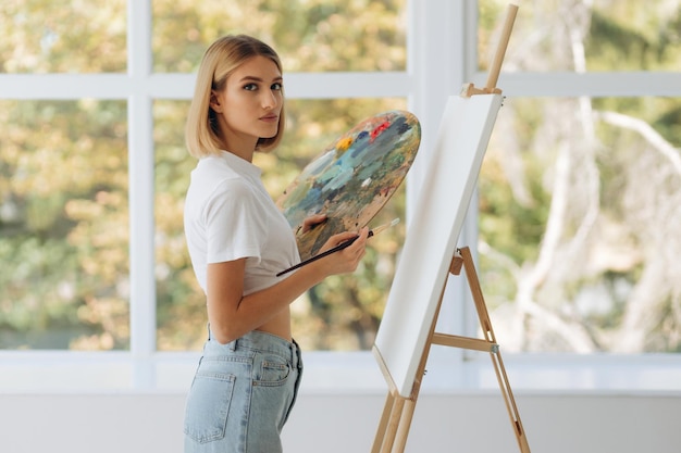 Portrait d'une belle artiste fine avec palette et pinceau