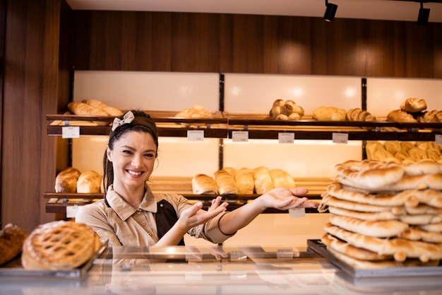 Portrait d'une belle boulangère debout dans une boulangerie